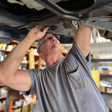 Mechanic inspecting car